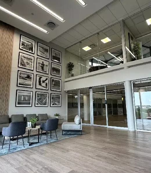 Light filled commercial lobby with aluminium sliding glass entrance and glass balustrades.